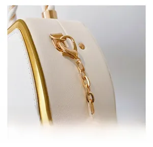 Detail of high-quality gold metal hooks and litchi grain white leather on a chain handbag