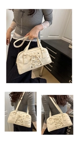 Detail view of cream shoulder bag featuring cross-lace design and silver metal hardware
