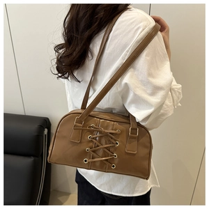 Close-up of brown PU leather shoulder bag featuring decorative cross-lacing design