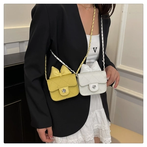 Detail of mini quilted chain bags with bow and rose metal buckle on model
