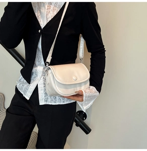 Detailed side view of a cream-colored crossbody bag on a model for daily styling