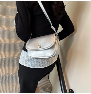 Fashionable silver crossbody bag shown on model highlighting metallic texture and shape