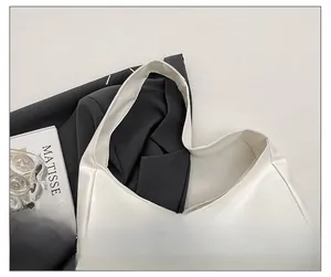 Close-up of a wide cream leather shoulder strap with integrated minimalist design