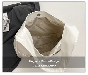 Detail of the magnetic snap closure and fabric lining of the white retro tote bag