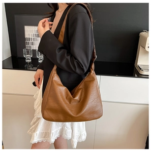 Große braune Shopper-Tasche aus strukturiertem PU-Leder, getragen von einem Modell