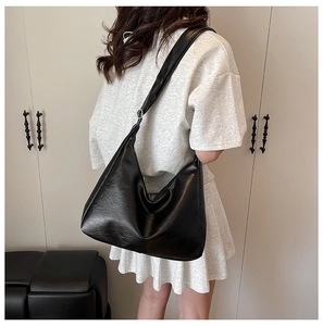 Detailansicht der Rückseite einer schwarzen Hobo-Tasche aus mattem PU-Leder an einem Model