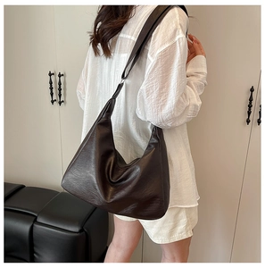Dunkelbraune Hobo-Bag aus weichem Leder am Modell für den lässigen Alltagsstil