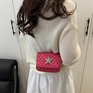 Borsa a tracolla fucsia trapuntata con stella d'argento e catena su maglione bianco
