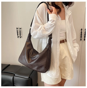 Dettaglio borsa hobo marrone scuro con tracolla larga e fibbia in metallo argento