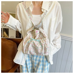 Close-up of floral cotton tote bag with a blue plaid bow and pink snap closure detail