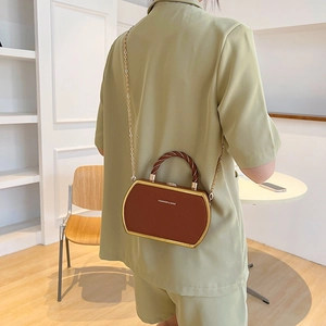 Brown vintage box bag with gold metal frame and woven handle worn across back