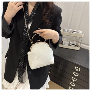 Détail du sac docteur vintage blanc avec tissu texturé, fermoir doré et bandoulière chaîne