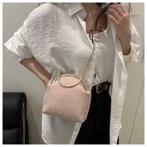 Detalle de textura jacquard rosa en bolso vintage con asa de metal dorado elegante