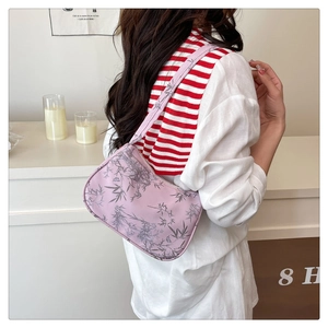 Close-up of light purple baguette bag with gray bamboo patterns on model's shoulder