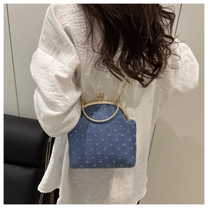 Bolso de boquilla en denim azul con lunares blancos y asa de anillo dorada en estilo urbano