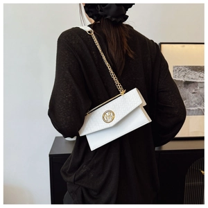 Detailed shot of white woven flap bag with golden M logo and chain strap on model