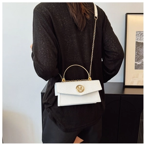 Detail of white litchi pattern leather bag with golden M buckle and chain strap