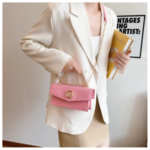 Detail of pink crossbody bag featuring woven texture and a gold M logo buckle