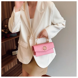Detailed shot of a pink crossbody bag with woven texture and a gold metal M logo buckle