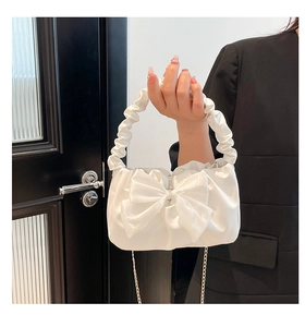 Detail of white bow handbag with ruched handle and silver chain strap for women