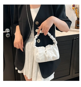 Detail of white PU leather handbag with oversized bow and ruched cloud handle