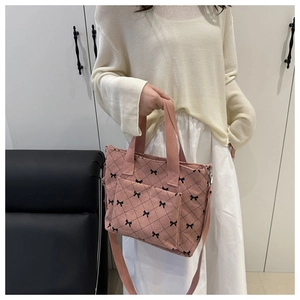 Détail du sac cabas en velours côtelé rose avec motifs nœuds noirs et anses solides