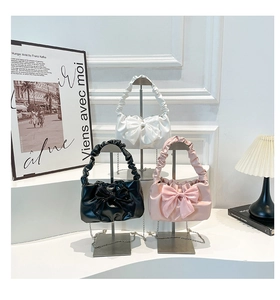 Chic vintage handbags featuring oversized bows and ruffled handles in three colors
