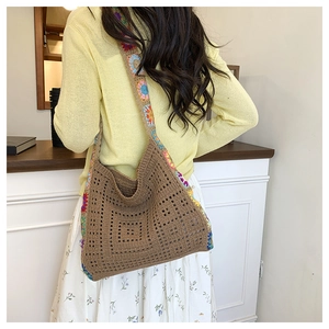Detail of hand-crocheted brown tote bag with multi-color floral shoulder strap
