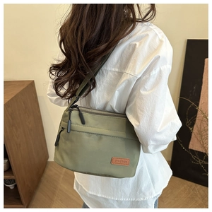 Vue arrière d'une femme portant un sac à bandoulière en nylon vert minimaliste