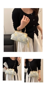 Detailed view of Chinese style handbag with golden floral embroidery and pearl handle