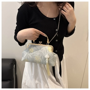 Close-up of elegant Chinese style floral brocade bag with golden metal chain and tassel