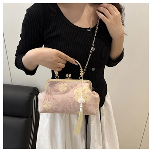 Close-up of pink floral cheongsam style handbag with golden chain and white tassel