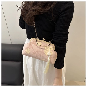 Detail of pink floral handbag with golden ball clasp and elegant long yellow tassel