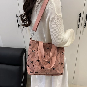 Borsa tote in velluto rosa con fiocco nero e motivo a rombi in vista elegante a 45°