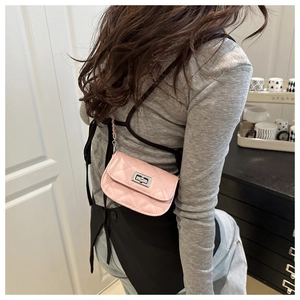 Close-up of a mini pink quilted crossbody bag with silver metallic twist lock and chain