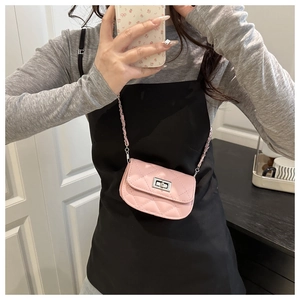 Close-up of pink quilted mini crossbody bag featuring a silver twist lock and chain strap