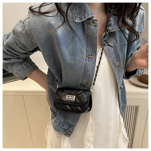 Detail of a mini quilted crossbody bag with silver twist lock and chain strap on model