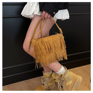 Détail du sac en daim jaune moutarde avec franges bohèmes et style urbain chic