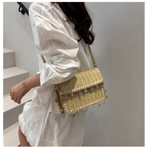 Détail du sac à bandoulière en paille beige avec bordure en dentelle blanche et coquillages