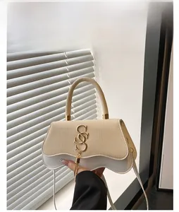 Close-up of white woven leather handbag with gold S-logo hardware and elegant tassel