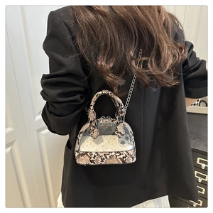 Detail of snake skin print transparent crossbody bag showing mini size with phone inside