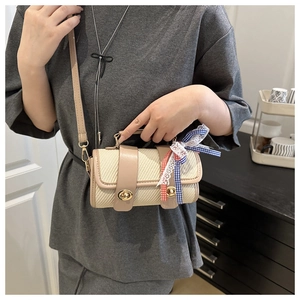 Détail du sac oreiller tissé avec garniture en cuir et ruban décoratif à carreaux