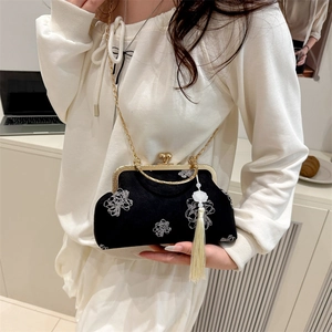 Elegant black shell-shaped handbag with white floral embroidery and gold chain strap