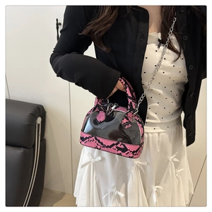 Detail of transparent PVC shell bag with pink snake skin trim and metal chain strap