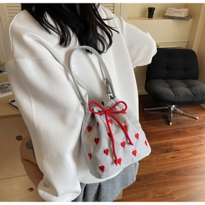 Detail of silver glitter bucket bag with red heart embroidery and drawstring closure