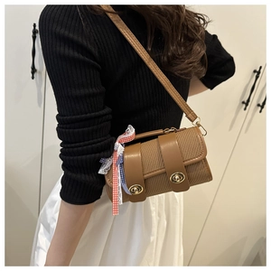Détail d'un sac à main tressé avec bordure en cuir marron et ruban décoratif