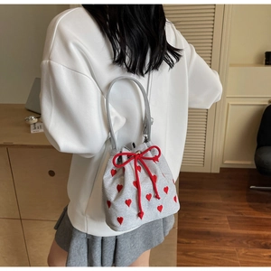 Detailed view of silver canvas bucket bag with red heart embroidery and drawstring