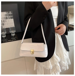 Close-up of white crocodile pattern underarm bag with elegant gold hardware detail