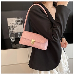 Detailed close-up of pink faux crocodile leather shoulder bag with golden metal lock