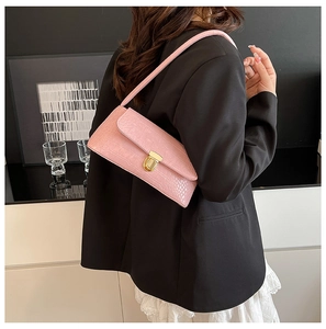Close-up of pink crocodile texture faux leather on underarm bag with gold metal buckle